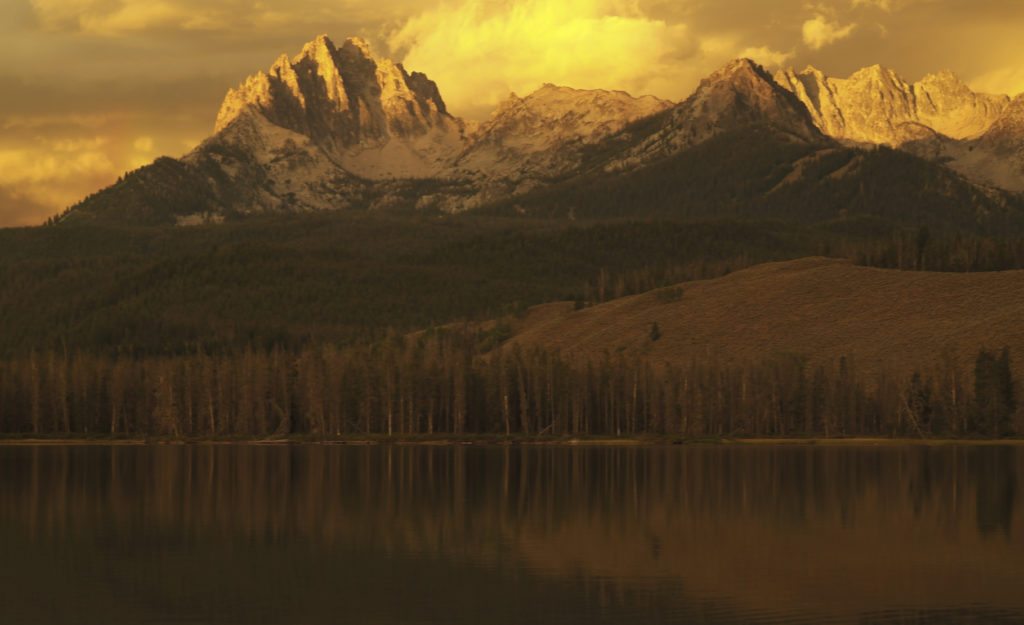 View of mountains beyond a lake in early morning light.